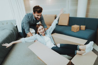 Genç bir çift yeni bir daireye taşıma sırasında eğleniyor. Evin etrafında haddeleme kutusu. Holiday Leisure. Mutlu aile hafta sonu sevinç. Birbirimizi seviyoruz. Yeni bir konut yeni evliler. Apartman dairesinde yer değiştirme.