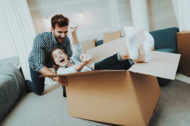 Genç bir çift yeni bir daireye taşıma sırasında eğleniyor. Evin etrafında haddeleme kutusu. Holiday Leisure. Mutlu aile hafta sonu sevinç. Birbirimizi seviyoruz. Yeni bir konut yeni evliler. Apartman dairesinde yer değiştirme.
