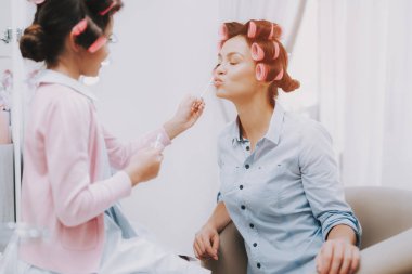 Curlers ile küçük hanım. Ruj olan kız. Kız Güzellik Salonu. Ruj elinde. Consept güzellik salonu. Güzel küçük hanım. Hizmet Consept. Fırçalar ile oynamak. Kız ve kadın. Güzel kadın.