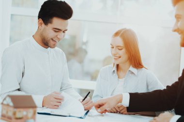 Genç bir çift. Rieltor kavramı ile Toplantı. Parlak Office. Bir sözleşme yaparak. Bir emlak alımı. Panoramik pencerelere. İş görüşmesi. Müşteri ve alıcı. Tartışma sunuyoruz. Profesyonel sözleşme.
