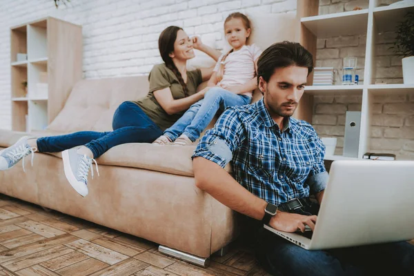 幸福的家庭 父母和女儿 一家人在一起休息 快乐的孩子和父母 公寓里有褐色沙发 在笔记本电脑上工作 坐在地板上的人 微笑的家庭休息 妈妈与女孩休息 — 图库照片