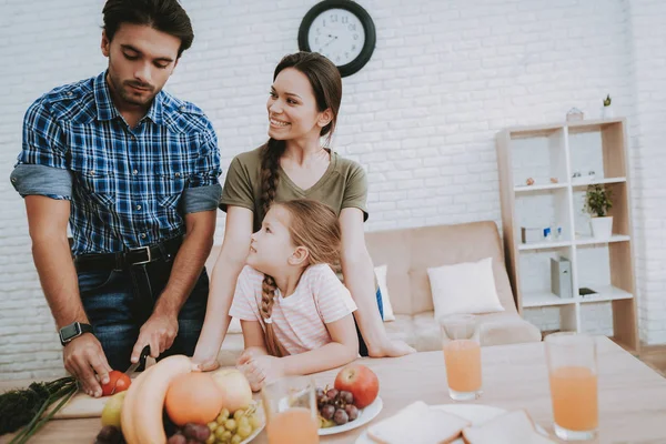 Man Cooking. Family Breakfast. Breakfast for Happy Family. Fruit on Plate. Bread on Plate. White plate. Juice in Glass. Food on Table. Happy family. Smiling People. Vegetables on Board. White Interior