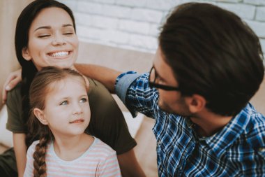Kucaklama kız ve kadın dostum. Küçük kız gülümsüyor. Gülümseyen aile evde. Gülümseyen kişi. Aile ile çocuk. Yeni parlak daire. Parlak daire insanlar. Anne ve Dougther. Kahverengi kanepe kişi