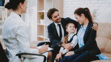 Aile Divan gülümseyerek. Psikolog paltolu. Danışmanlık psikolog. Psikolog'ın ofisi. Öneriler yazmak. Not defteri ve kalem. Anne ve kızı. Aile ve doktor. Psikolojik oturum.