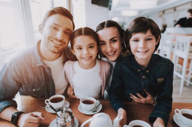 Genç aile. Cafe. Mutlu birlikte. Anne ve oğlu. Baba ve kızı. Etkin boş zaman. Şirin ilişki. Kutlama. Genç aile. İyi bir ilişki. Aile tatili. Çay saati. Gülümseyen insanlar.