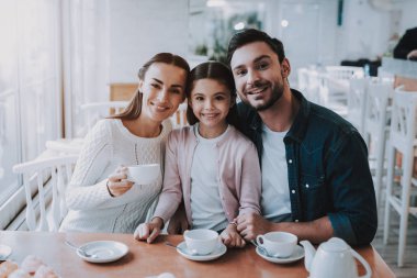 Aile günü. Çay saati. Anne. Baba ve kızı. Tatlım. Nefis. Cafe. Mutlu birlikte. İyi bir ilişki. Aile tatili. Etkin boş zaman. Şirin ilişki. Kutlama. Gülümseyen insanlar. Genç aile.