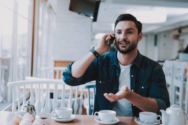 Genç adam Cafe. Smartphone. Demlik çay için. Restoranda oturan adam. Konuşkan çocuk. Mutlu hafta sonu. Çay kap. Kafeterya. Diner. Kapuçino içmek. Espresso Bar. Kahve molası. Serbest meslek.