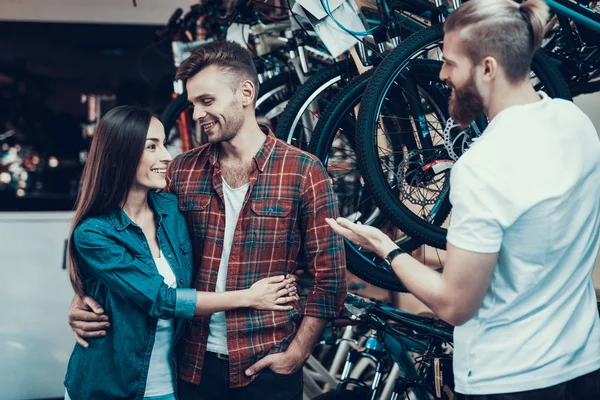 Consultor Ajuda Jovem Casal Escolha Bicicleta Assistente Loja Barbudo Mostra — Fotografia de Stock