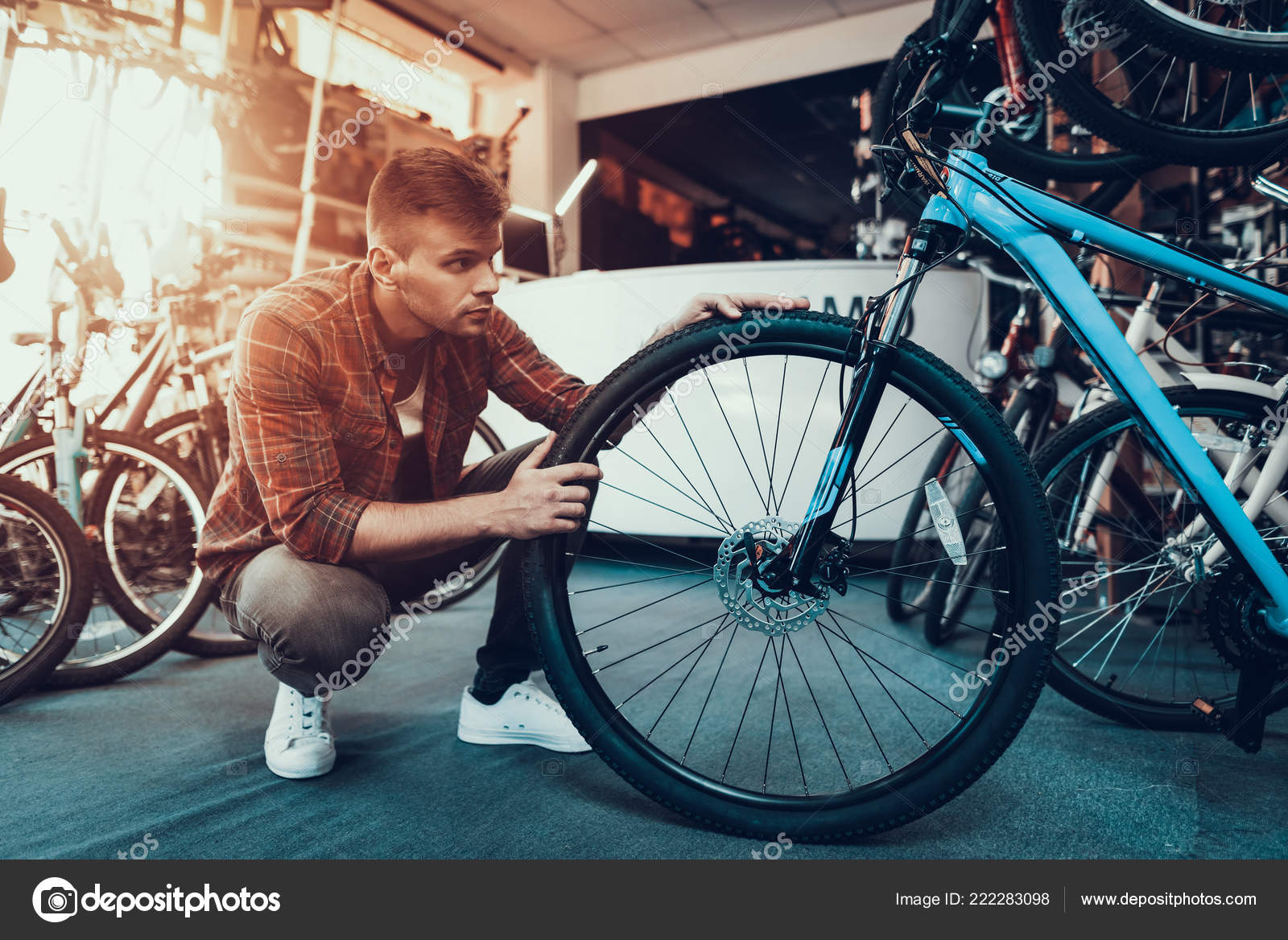 Primer plano de un atractivo hombre adulto guapo mecánico de bicicletas  inflando la rueda de la bicicleta día mundial de la bicicleta