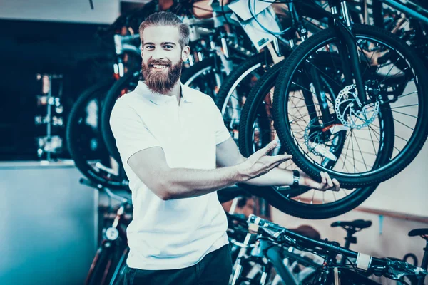 Lächelnder Junger Mann Zeigt Mit Dem Finger Auf Moderne Fahrräder — Stockfoto
