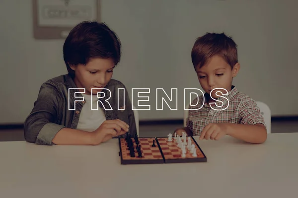 つの退屈少年チェスのテーブルに座っています 家庭用レジャー 子供たちの休日の活動 友人と週末 家族関係 移動をします 論理的なゲーム 机の上の数字します スマートキッズ — ストック写真
