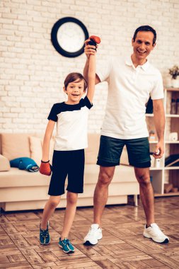 Çocuk ayakta eller yukarı. Evde spor. Yukarı üç aylık dönemde sıcak. Boks eldivenleri. Spor yapıyor. Dostum ve oğlum evde tren. Boks eldivenleri dairesinde çocuk. Küçük boksör şampiyonu. Evde eğitim.
