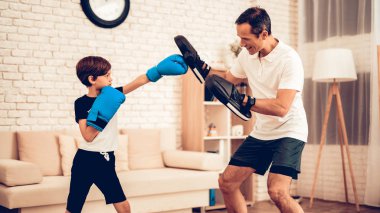 Erkek Boxer. Baba ve oğul Spotting yapmak. Evde spor. Yukarı üç aylık dönemde sıcak. Tablet elinde. Boks eldivenleri. Spor yapıyor. Dostum ve oğlum evde tren. Boks eldivenleri dairesinde çocuk. Küçük çocuk.