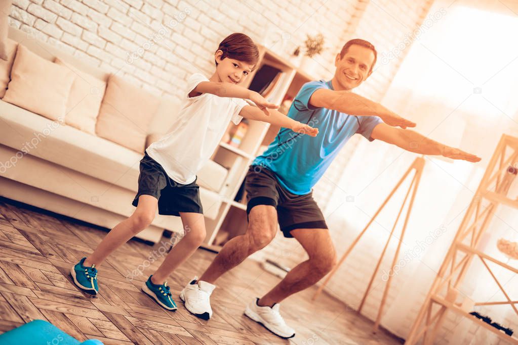 Boy Standing on Scales. Father and Son do Spotting. Sport at Home. Warm Up in Quarter. Lying on Gymnastic Mat. Dumbbells in Hands. Boxing Gloves. Doing Sports. Man and Boy Train at Home. Swing Press. 