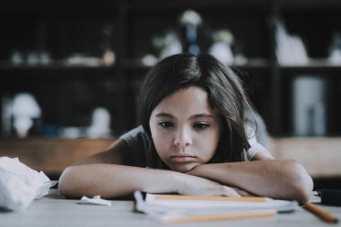 Küçük kız masada yalan sıkılmış ifade gösterir. Siyah saçlı çocuk portresi masaya döşeme el ve beyaz defter kalem ile bakar kafa tutar. Can sıkıntısı ve tembellik kavramı