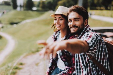 Genç çift oturma çıkıntı ve Parkı'nda arıyorum. Genç adam ve kadın ile birlikte uçurumun kenarında oturan sırt çantaları. Doğanın güzel manzarayı çift. Seyahat kavramı