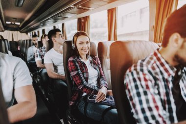 Gülümseyen kadın turist otobüsü müzik dinleme. Genç güzel kadın rahatlatıcı Kulaklığımda tur otobüs yolcu koltuğunda. Seyahat, turizm ve insanlar kavramı. Mutlu seyahat gezi