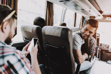 Yakışıklı adam eğlenceli seyahat Tur otobüste sahip. Turist otobüsü ve geri seyir yolcu koltuğunda oturan çekici gülümseyen adam. Seyahat ve Turizm kavramı. Mutlu seyahat gezi