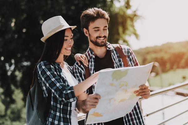 年轻的微笑的夫妇看着地图户外 卡萨布兰卡穿着快乐的旅行者背包规划路线一起看纸地图 旅游和友谊概念 — 图库照片