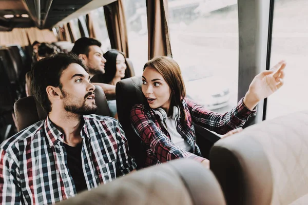 年轻的微笑的夫妇在旅游巴士上旅行 英俊的男人和美丽的女人放松在旅游巴士的乘客座位和谈话 旅游和人的概念 旅行中的愉快旅行者 — 图库照片
