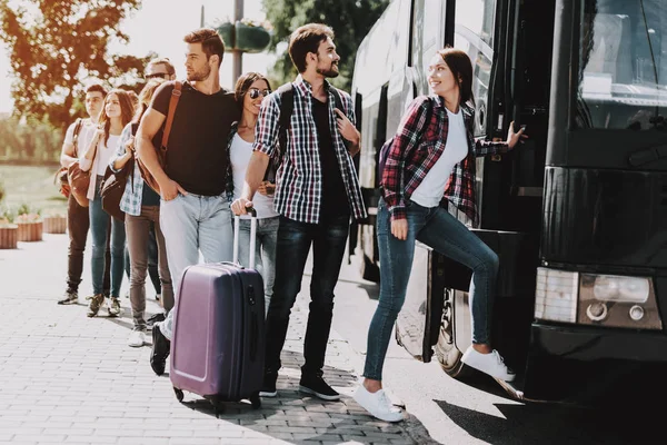 旅行バス上若い人搭乗のグループ 幸せな出張は 入力バスに自分の順番を待っている荷物を保持しているキューに立っています の概念 夏の休暇 — ストック写真
