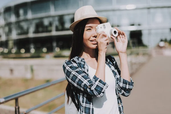 美丽的女人的肖像拍照相机上 年轻的有吸引力的妇女穿着帽子和检查衬衫关闭脸与白色相机 微笑快乐的女孩享受阳光明媚的一天 创意摄影师 — 图库照片