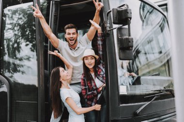 Genç gülümseyen insanlar Turizm otobüste seyahat. Grup mutlu arkadaşıyla birlikte tur otobüsü kapı ayakta. Seyahat, turizm ve insanlar kavramı. Mutlu seyahat gezi. Yaz tatili