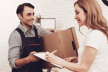 Kurye. Kahverengi kutusu olan adam. Beyaz iç. Teslimatçı Arap Milliyet. Kurye Mavi giysili. Hızlı teslimat. Kağıt paket verir. Kağıt kutusu. Gülümseyen kız işareti Master için.