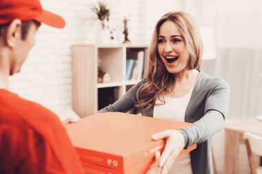 Pizza teslimatı. Pizza teslimatçı. Pizza kızla. Adam kutusu ile komik bir aksesuardır. Teslimatçı Arap Milliyet. Kurye turuncu giysileri. Fast Food. Hızlı teslimat. Pizza kutusu ile gülümseyen kız.