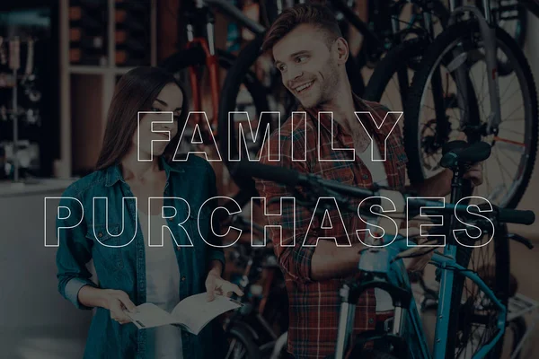 Family Purchases. Customers Choosing a Bicycle. Customers is Couple of Man and Woman. Woman Holding a Catalog of Bicycles. Man Holding a Bicycle. Woman are Doubts in Choose. Man Happy and Smiling.