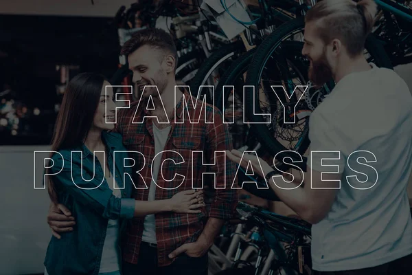 Family Purchases. Customers Choosing a Bicycle. Salesman Showing Bicycle to Customers. Customers is Couple of Man and Woman. Couple Hugging Each Other. People Happy and Smiles. Bicycle Shop.