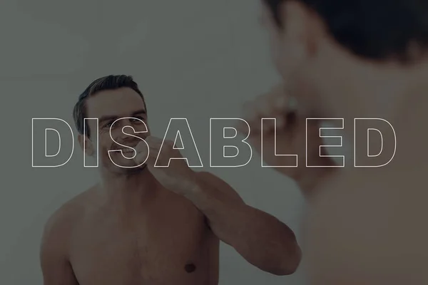 Disabled Man. Man Looking at Himself in the Mirror. Man is Happy and Smiling. Man is Brushing Her Teeth with Toothbrush. Naked Man. Adult Caucasian Brunette Man. Man Located in Bathroom.