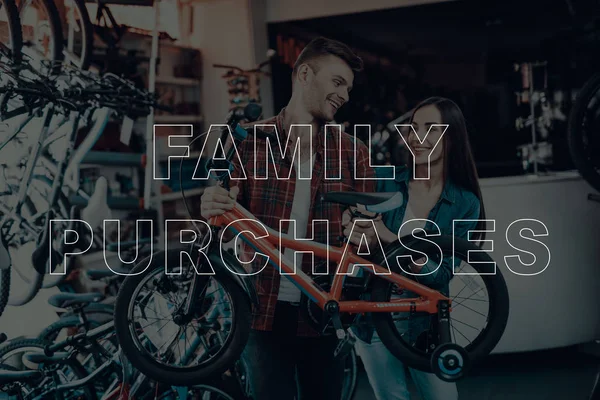 Family Purchases. Customers Choosing a Bicycle for Himself. Customers is Couple of Man and Woman. Customers Holding a Bike. Bike for Little Children. Couple Happy and Smiling. Bicycle Shop.