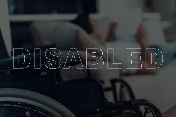 Behinderter Mann Mann Auf Sofa Liegend Rollstuhl Auf Dem Hintergrund — Stockfoto