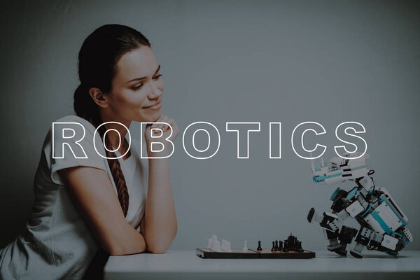 Chessboard. Play. Move. Woman's Hand. Small. Robot. Stand. Design. Digital. Happiness. Happy. Home. House. Interior. Machine. Relationship. Technology. Mechanical. Innovation. Smile.