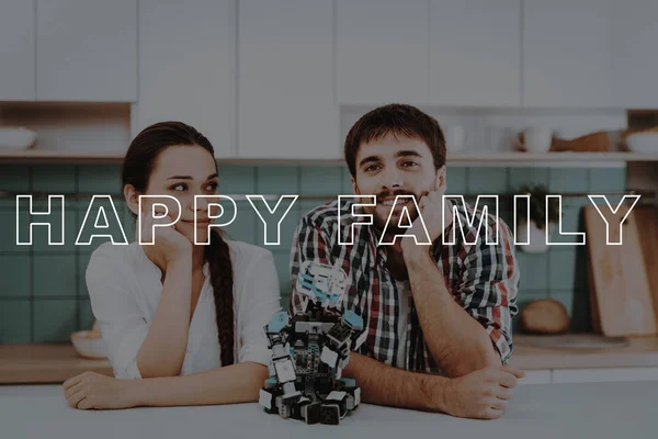 Gift. Designing Robots. Happy. Leisure Time. Young Couple. Kitchen. Bubbly Relationships. Help. Guy. Work Together. Man. Robot. Girl. Smiling. Beautiful. Have Fun. Family. Home. Happiness.