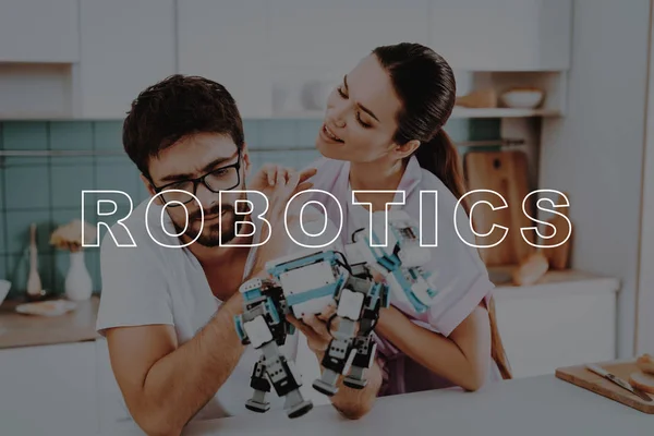 Robot. Man. Collect. Kitchen. Girl. Hugs. Smiling. Beautiful. Pink Robe. Happy Together. Leisure Time. Have Fun. Family. Designing Robots. Home. Spare-Time. Off-Time. Happiness. Bubbly Relationships.