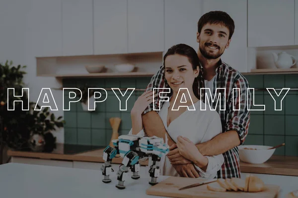 Hugs. Posing. Cooking. Focused. Robot. Happy. Leisure Time. Designing Robots. Young Couple. Kitchen. Relationships. Help. Guy. Work Together. Man. Girl. Smiling. Have Fun. Family. Home. Happiness.