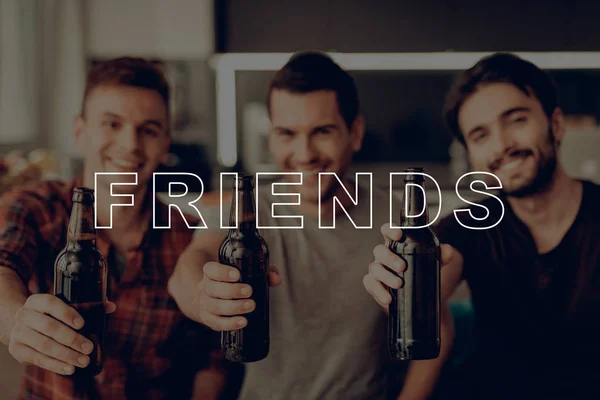 Posing for Photo. Talk. Three Men. Drink Beer. Dark Bottles. Sit on Couch. Smiling. Party. Guys. Best Friend Forever. Happy Together. Celebration. Friend. Having Fun. Spend Time Together. Cheerful.