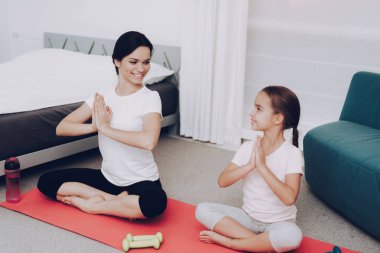 Genç kızı ile meditasyon için iyi günler. Yoga tüm insanlar için. Evde yoga. Sağlıklı anne ve sağlıklı kız. Evde annesi ile tüm genç eğitim için motivasyon. Gülümseme anne ve kız.