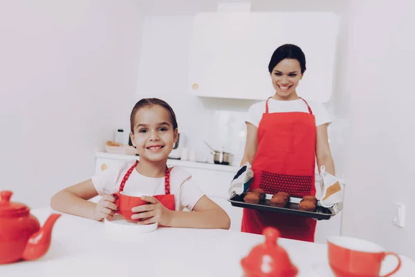 Mom and Happy Girl Cook in Kitchen. Beautiful Smile Girl and Smile Mom. Help with Preparation Kitchen. Familly Bake Together. Apron with Girl and Mom. Biscuit for Big Family. Dessert for Daughter.