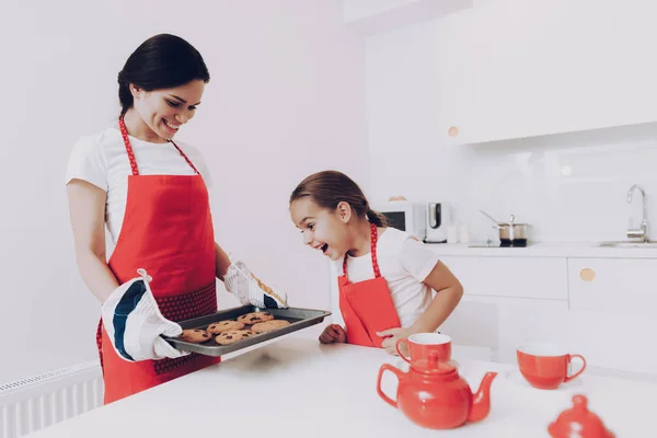 Apron for Mom and Daughter. Bake a Biscuit For all Family. Cheerful and Happy Family Bake a Cake Together. Child with Mom Bake a Cake. Happy Mom and Happy Daughter in Kitchen. Childhood on Kitchen.