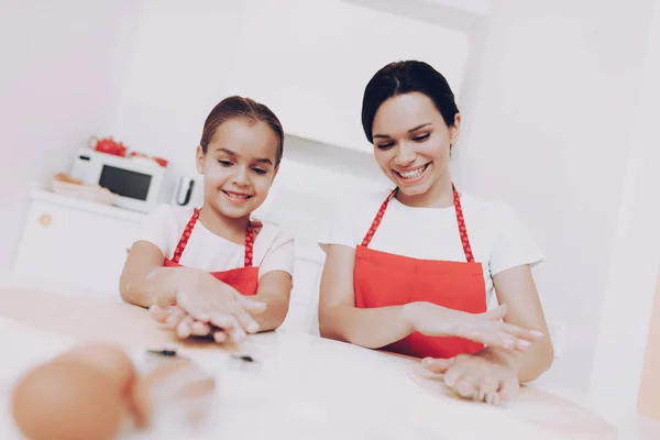 Mom Teaches Young Girl. Cook with Mom Smile Girl and Mom Cook Together. Preparation Dough for Cake. Help Daughter with Dessert. Motherhood for Mom. Rolling Dough People Cook on Kitchen. Help Girl.