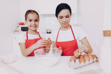 Aile hazırlık gıda bütün aile için. Anne ve kız hazırlık tatlı pasta için tüm malzemeyi. Annem fırında ile bir pasta bir gülücük. Pasta ile yardım genç kız anne. Mutfak annesi ile mutlu kız.
