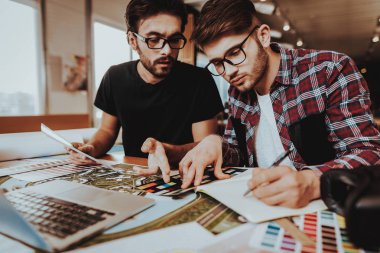 Birlikte kapalı çalışan iki serbest tasarımcı. Yoğun grafik çizerler portresi Not defteri, masada oturan dizüstü kullanarak proje üzerinde duruldu. Ekip çalışması Coworking kavramı