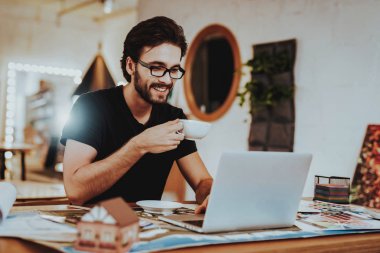 Gülümseyen genç grafik tasarımcı kahve molası vardır. Kapalı çalışma alanı içecek çay oturan Projesi'nde çalışan mutlu profesyonel çizer portresi. Yaratıcı çalışma kavramı