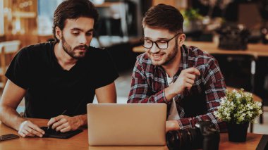 Serbest çalışan fotoğrafçılar İnceleme Fotoğraf laptop. İki genç adam kameraya bakarak dizüstü bilgisayarda çalışırken tartışmaya çalışma Studio Office ekran. Serbest takım çalışması ve işbirliği kavramı