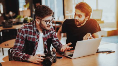 Fotoğrafçılar fotoğraf makinesi inşaat üstünde Laptop ile kapalı. İki profesyonel kamera kullanır kişisel bilgisayar çalışma Studio Office monitör bakarak tutun. Takım çalışması ve işbirliği kavramı
