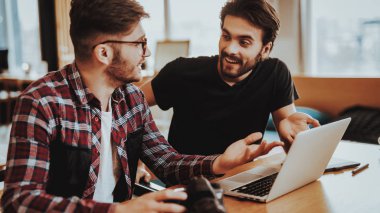 İki adam, dizüstü bilgisayarda çalışırken tartışıyor. Grafik tasarımcıları kullandığı kişisel bilgisayar çalışma Studio Office monitör bakarak. Serbest takım çalışması ve işbirliği kavramı