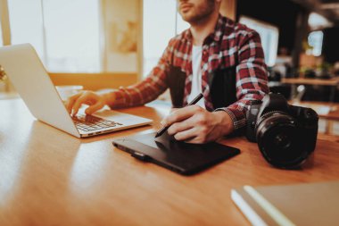 Grafik tasarımcı çalışma İşyerinde closeup. Stylus kalem ve Laptop klavye kapalı ile dijital Tablet kullanarak tablo rötuş fotoğraf oturan adam. Freelancing ve mesafe iş kavramı